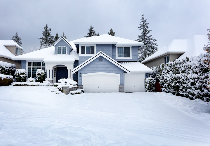 Snow storm in Northwest United States with residential home and dark sky in background