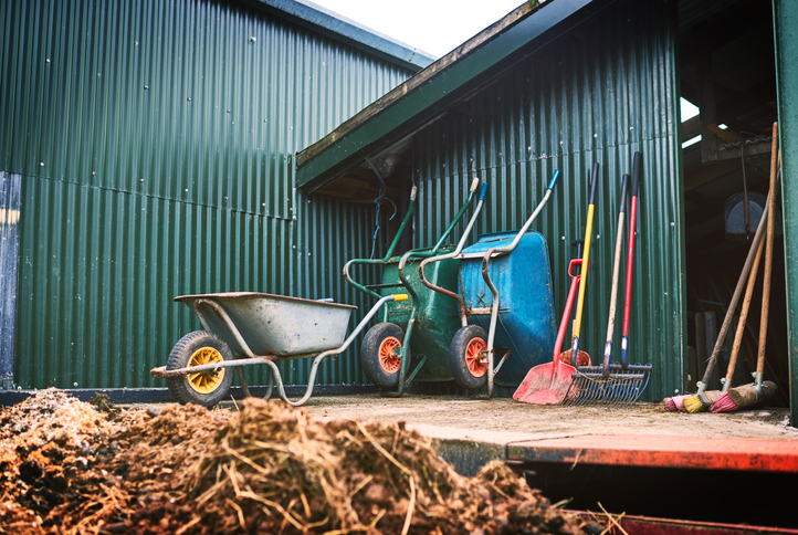 Shot of farming tools against a barn outside